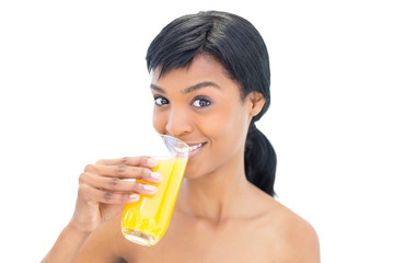 Dynamic black haired woman drinking orange juice