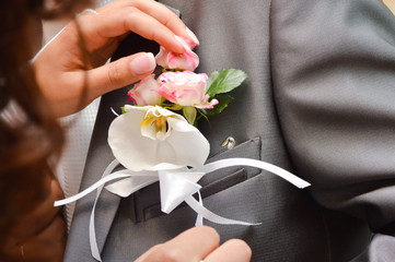 Beautiful orchid boutonniere on groom suit