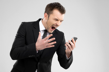 Angry businessman. Angry young man in formalwear shouting at mob
