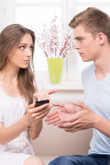 Relationship difficulties. Sad young woman pointing mobile phone