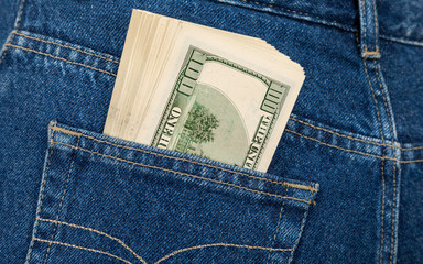Stack of hundred dollar bills in the back jeans pocket