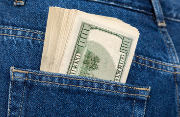 Stack of hundred dollar bills in the back jeans pocket