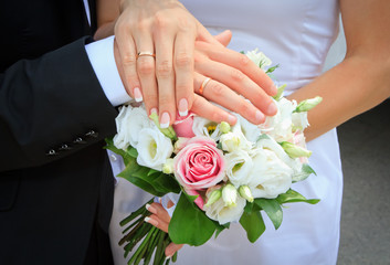 Obraz na płótnie Canvas Ręce i pierścienie na bukiet ślubny