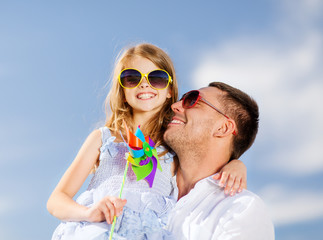 happy father and child in sunglasses over blue sky