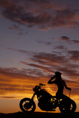 Obraz na płótnie Canvas silhouette of woman motorcycle sit backwards hand