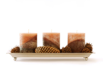 Drei braune Kerzen in einer Schale