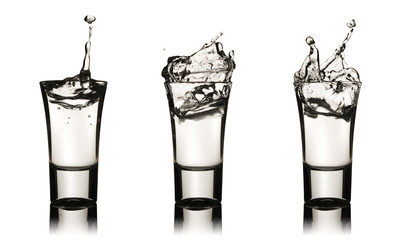 Three vodka glasses with splashes - obrazy, fototapety, plakaty