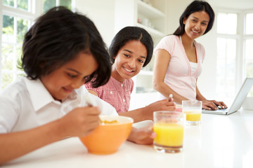 Children Having Breakfast With Mother Before School