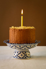 Chocolate Birthday Cake With Almond Flakes And Burning Candle