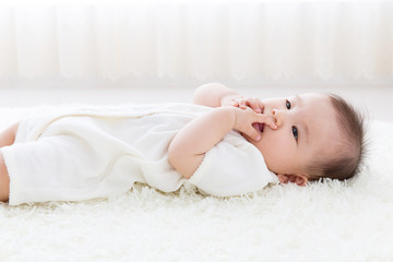 Obraz na płótnie Canvas asian baby on the white carpet