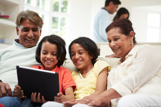 Multi-Generation Indian Family With Digital Tablet