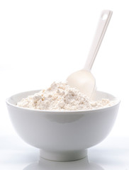 porcelain white bowl with spoon full of flour