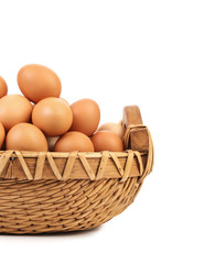 Brown eggs in the basket on white