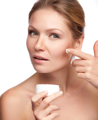 Woman applying cosmetic  cream on a clean fresh face