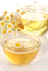 Cup of herbal tea with camomiles close up