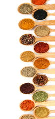 Assortment of spices in wooden spoons, isolated on white