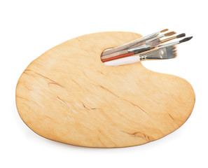 Brushes and a palette of the painter isolated on a white