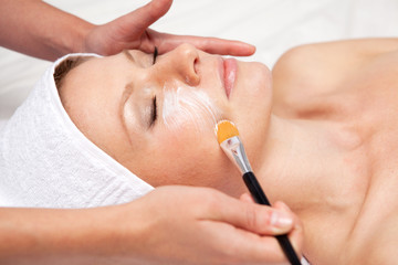 Obraz na płótnie Canvas Spa therapy for woman receiving facial mask at beauty salon