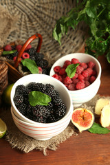 Assortment of juicy fruits and berries on wooden background
