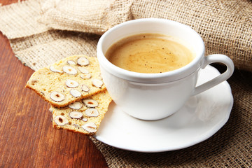 Cup of tasty coffee with Italian biscuit, on wooden background