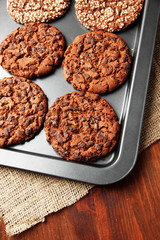 Homemade cookies on dripping pan, on wooden background