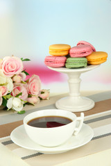 Coffee and macaroons on table on light background