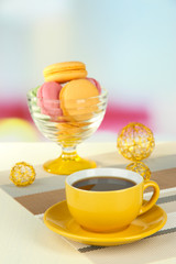 Coffee and macaroons on table on light background