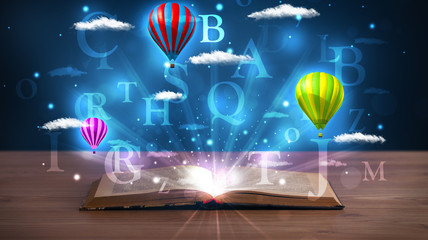Open book with glowing fantasy abstract clouds and balloons