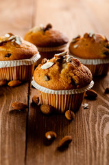 Muffins with almonds on a wooden table