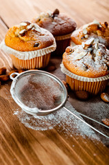 Muffins with almonds on a wooden table