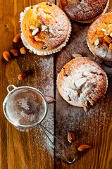 Muffins with almonds on a wooden table