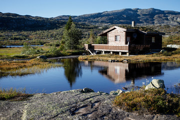 Fototapeta na wymiar small hut at norwegian lake in hardanger vidda
