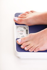 Woman feet and weight scale isolated on white background