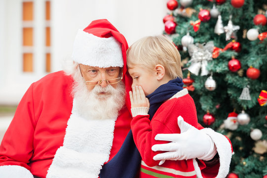 Boy Whispering In Santa Claus's Ear