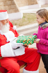 Obraz premium Girl Receiving Present From Santa Claus