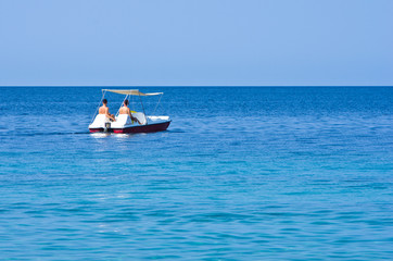 Couple driving a pedal boat on a vacation at Aegean sea