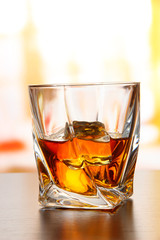 Glass of whiskey, on bright background
