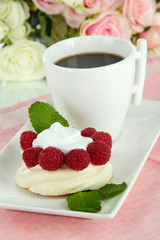 Tasty meringue cake with berries and cup of coffee
