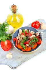 Sliced fresh vegetables in pan on wooden board isolated on