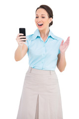 Fototapeta premium Cheerful classy businesswoman looking at her smartphone