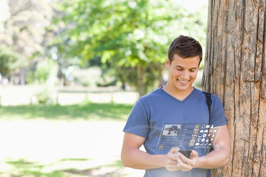 Cheerful handsome student using his digital smartphone - Powered by Adobe