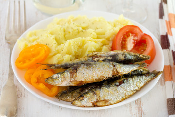fried sardines with potato on the plate