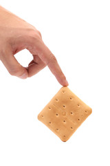 Hand holds saltine soda cracker.