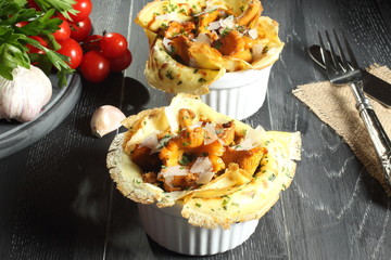 crespelle con funghi sformato di finferli su sfondo grigio 