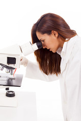 Scientist looking through microscope a sample of blood, isolated