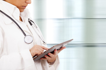 Confident female doctor using tablet computer in corridor of the