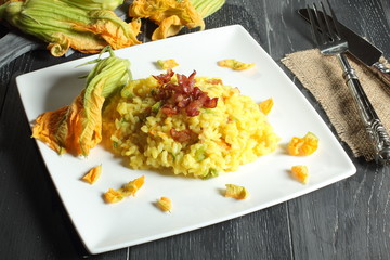 risotto con fiori di zucchino tavolo grigio sfondo verde