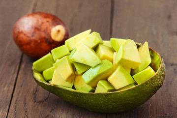 Chopped avocado fruit on brown wooden old table