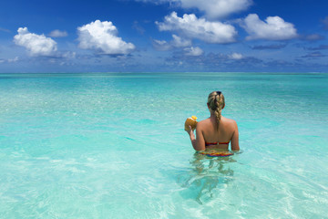 Fototapeta na wymiar Girl with coconut in the ocean