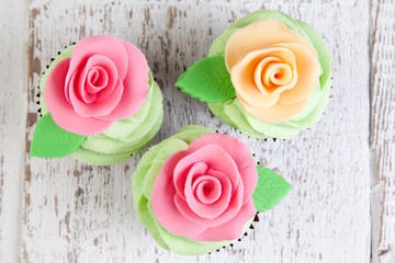 three cupcakes with roses